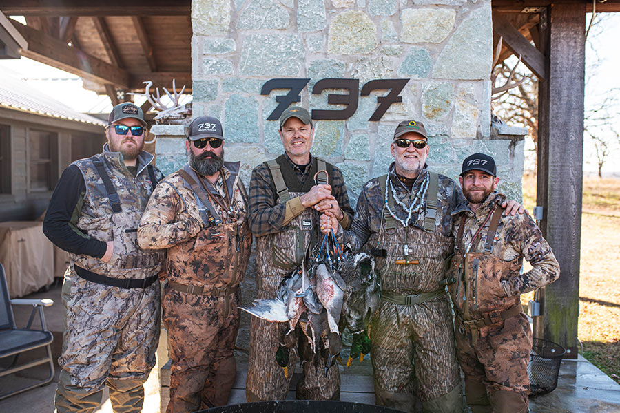 five duck hunters with ducks
